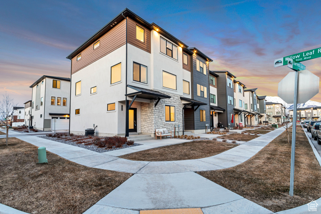 Outdoor building at dusk featuring a garage and central air condition unit