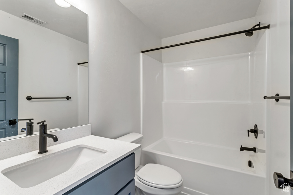 Full bathroom with vanity, toilet, and  shower combination