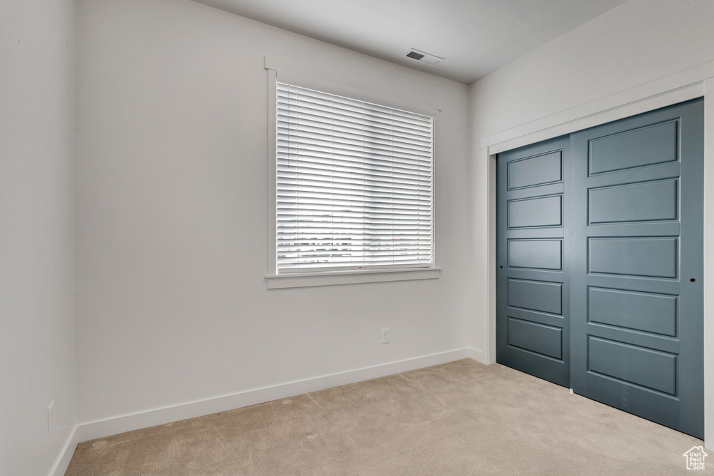 Unfurnished bedroom featuring a closet and carpet floors