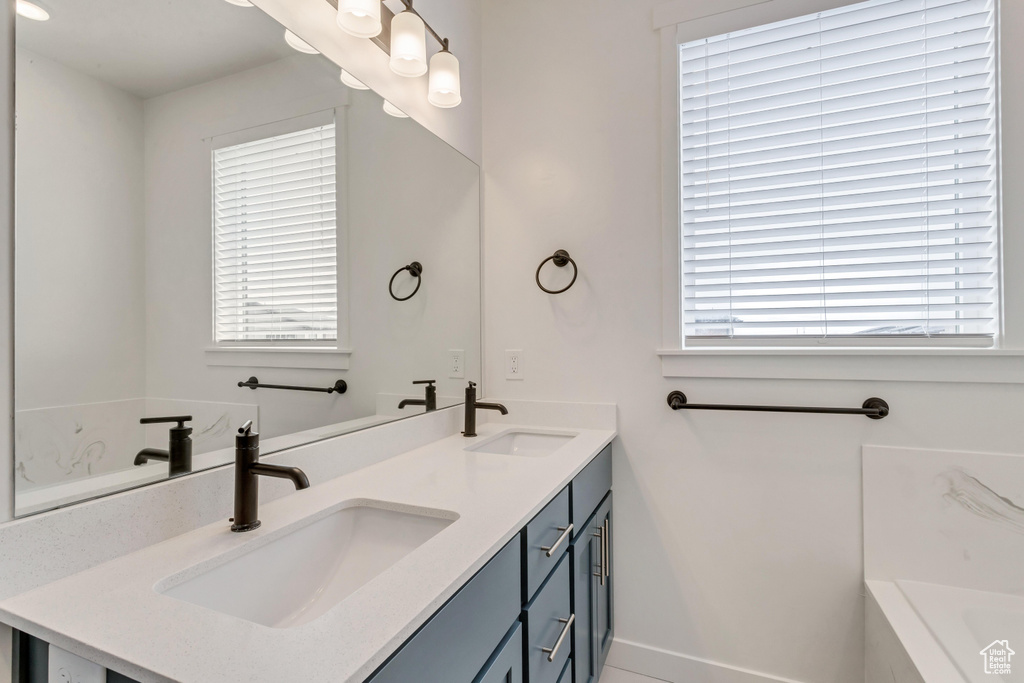 Bathroom featuring a tub and double vanity