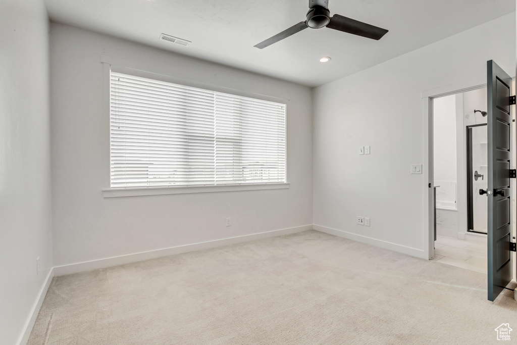 Unfurnished room featuring light colored carpet and ceiling fan