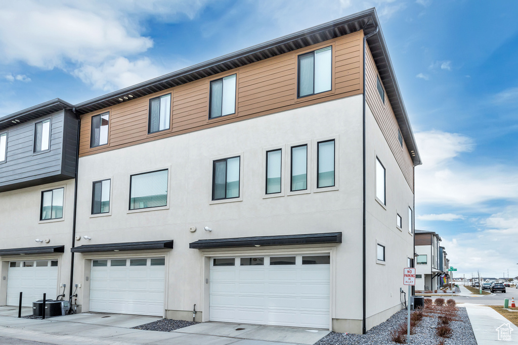 View of front of home featuring a garage and central AC unit