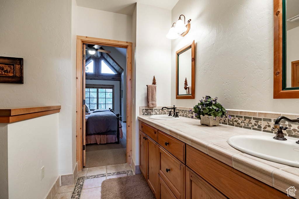 Bathroom with tile flooring, double sink vanity, and ceiling fan