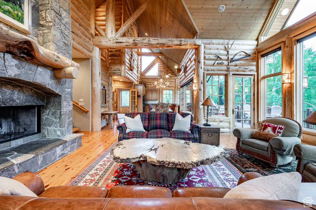 Living room featuring a fireplace, wooden ceiling, high vaulted ceiling, wood-type flooring, and log walls