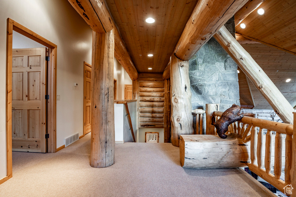 Corridor featuring carpet, rustic walls, and wooden ceiling