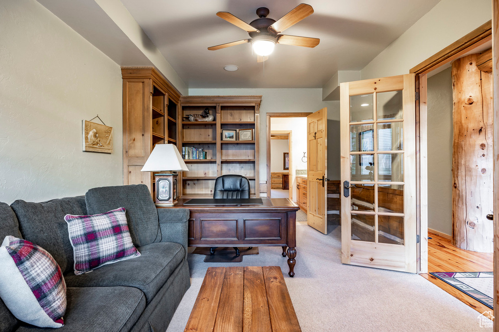 Living room with ceiling fan and light colored carpet