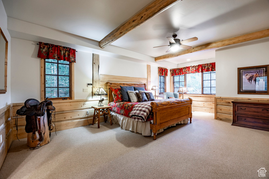 Carpeted bedroom with beam ceiling and ceiling fan