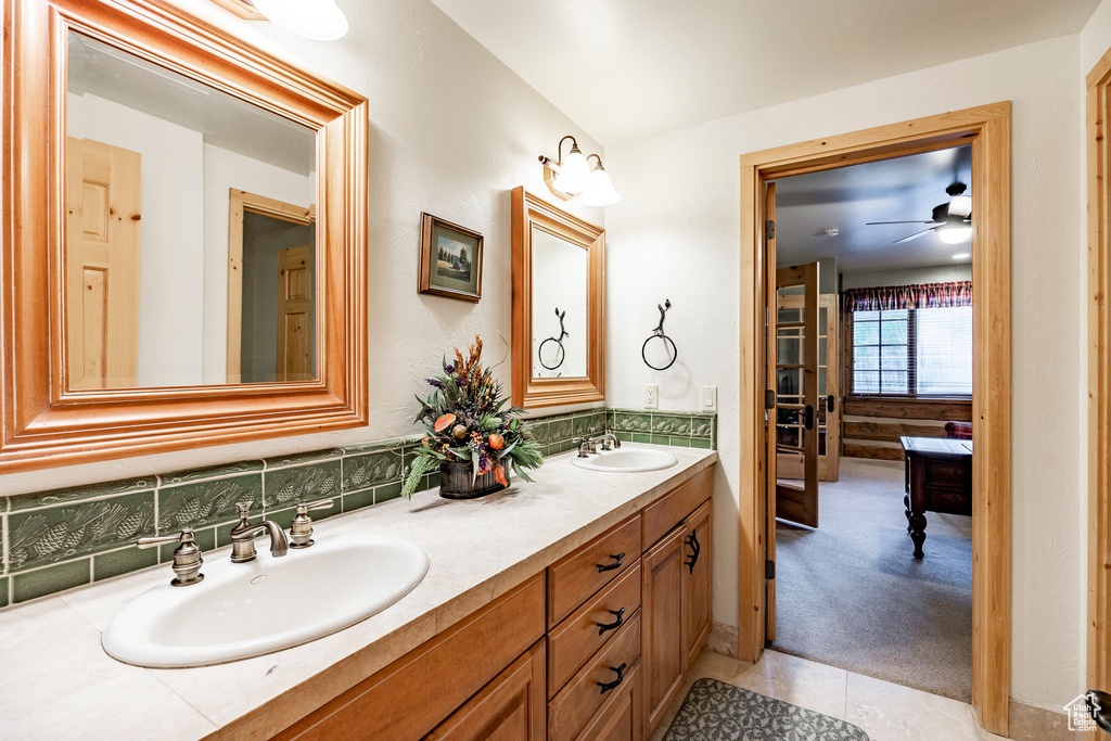 Bathroom featuring oversized vanity, ceiling fan, tile floors, tasteful backsplash, and double sink