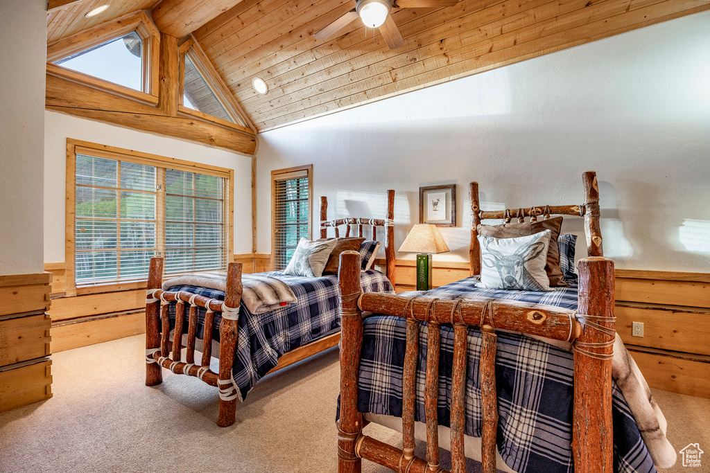 Carpeted bedroom featuring wooden ceiling, lofted ceiling with beams, and ceiling fan