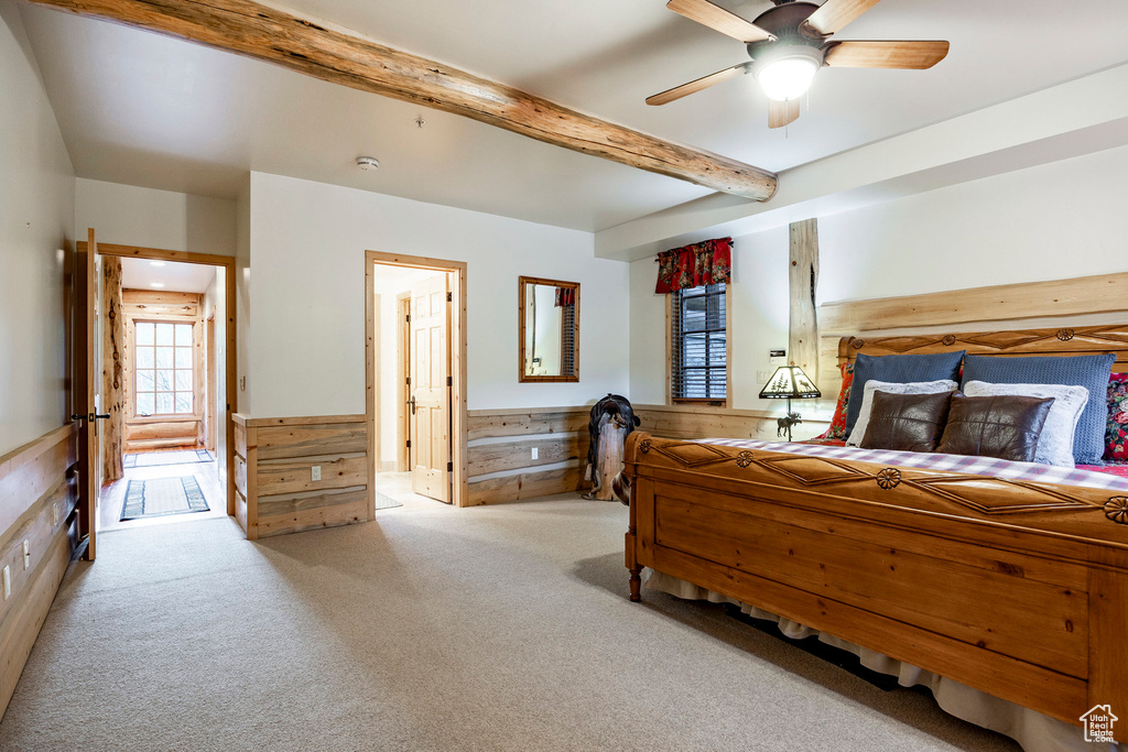 Carpeted bedroom featuring ceiling fan and beam ceiling