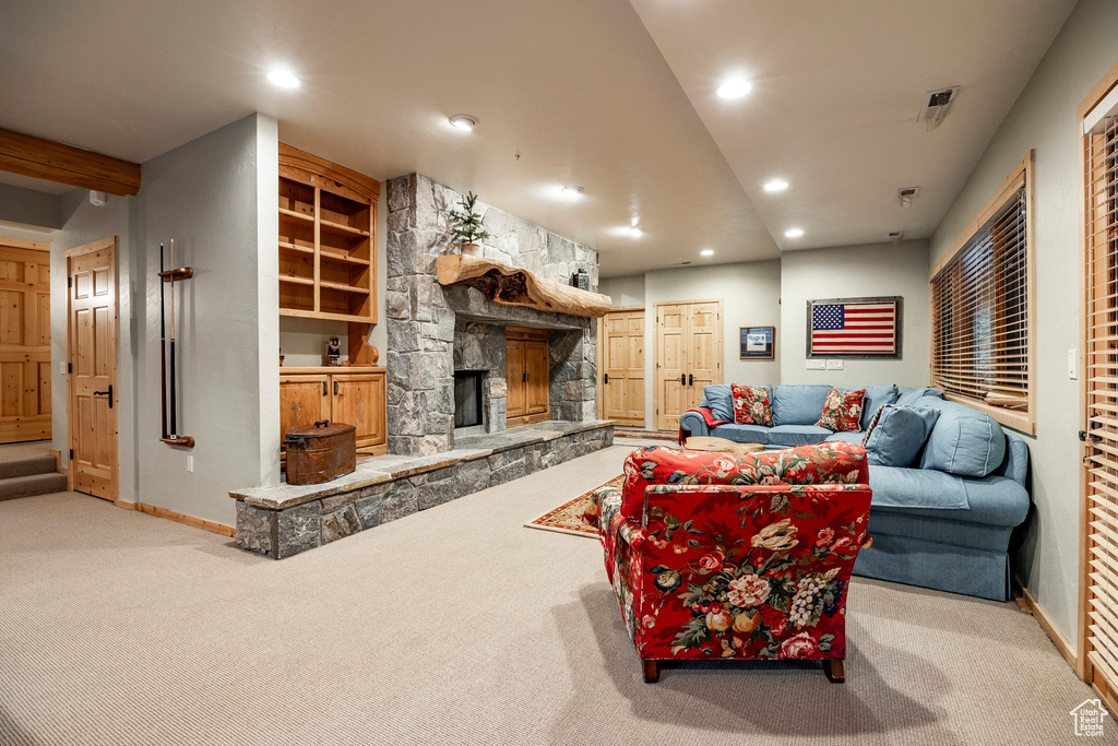 Living room with a stone fireplace and carpet