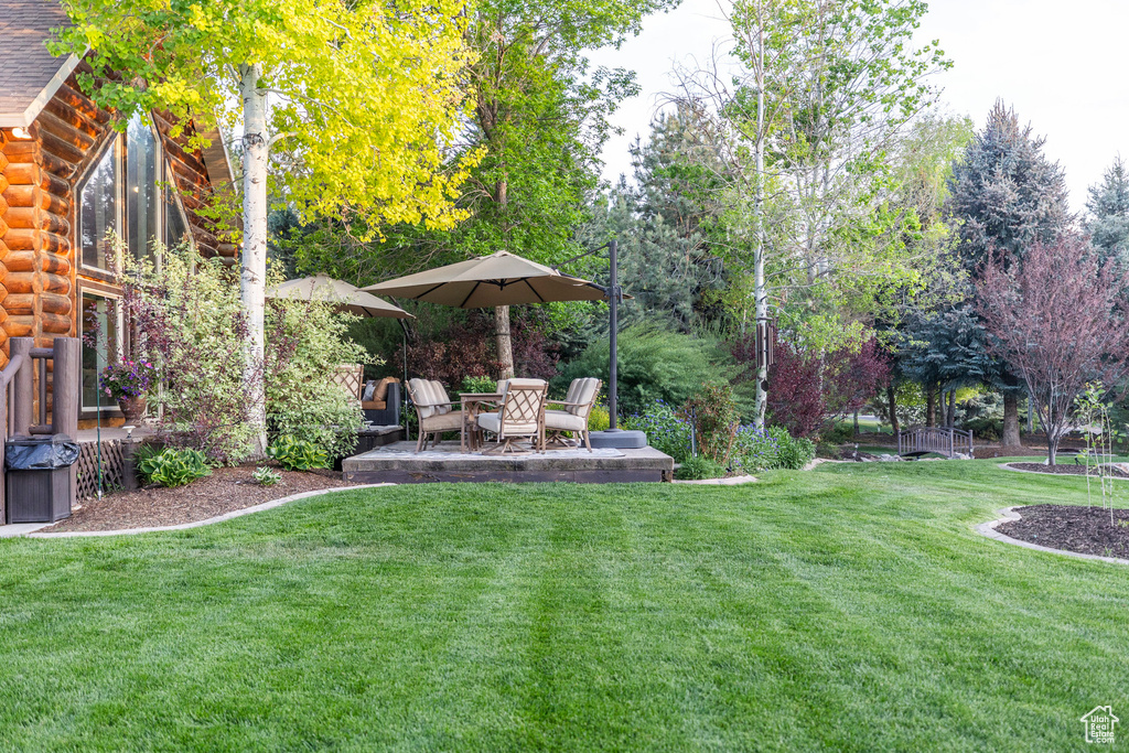 View of grassy yard featuring a patio area