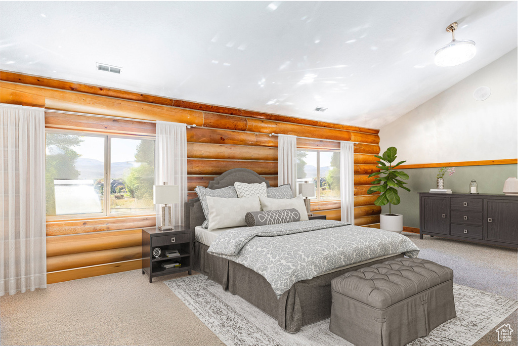Carpeted bedroom with rustic walls and lofted ceiling