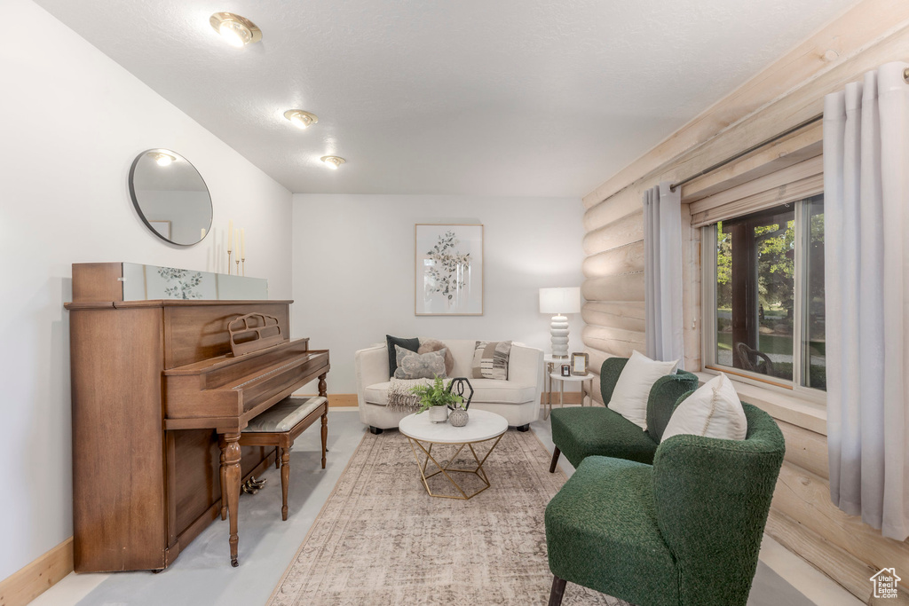 Living area with baseboards and log walls