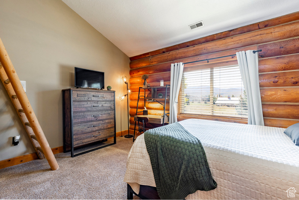 Bedroom with rustic walls, baseboards, carpet flooring, and lofted ceiling