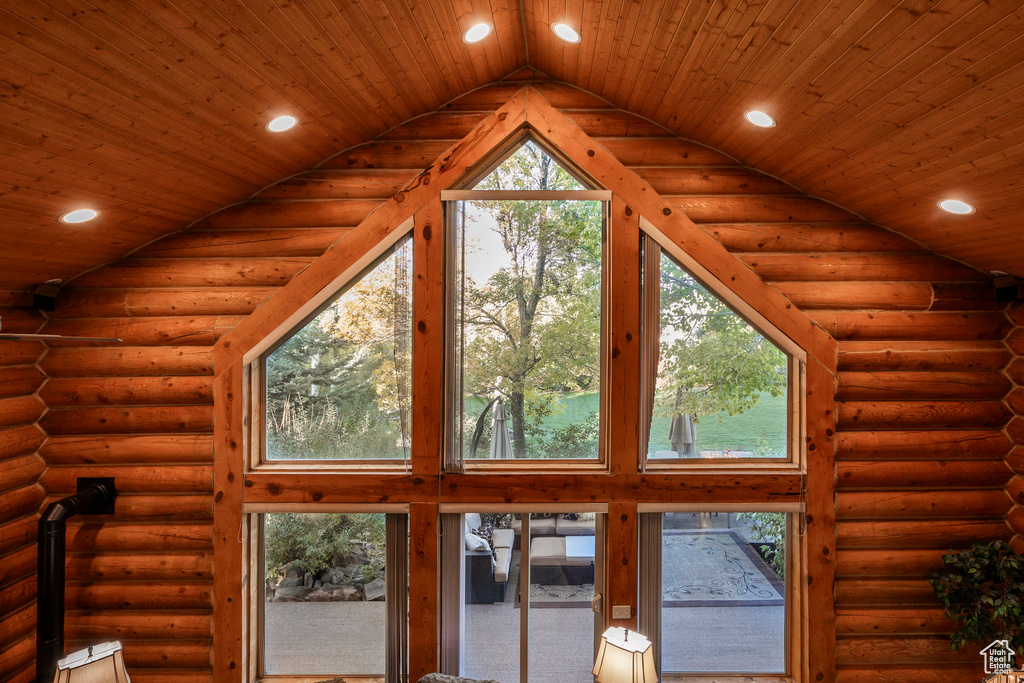 Detailed view of recessed lighting, log walls, and wood ceiling