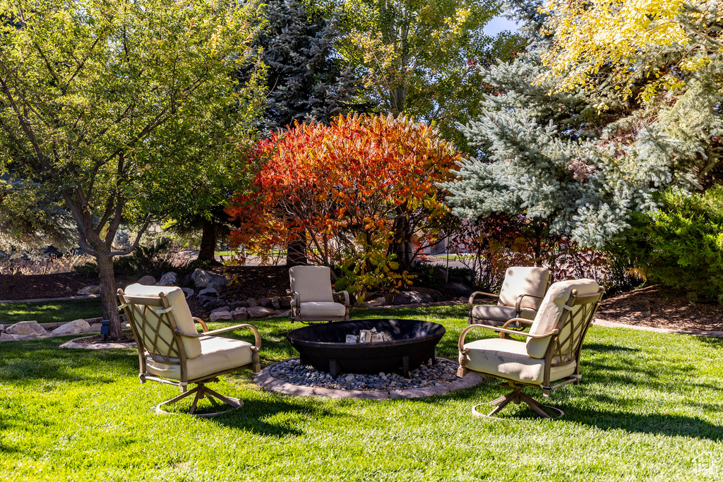 View of grassy yard featuring an outdoor fire pit