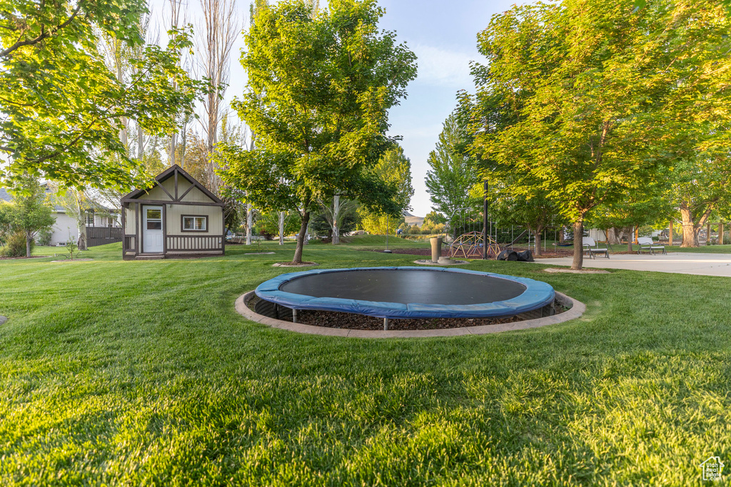 View of green lawn featuring a trampoline