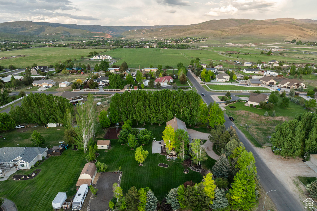 Aerial view of property and surrounding area with a mountain backdrop and nearby suburban area