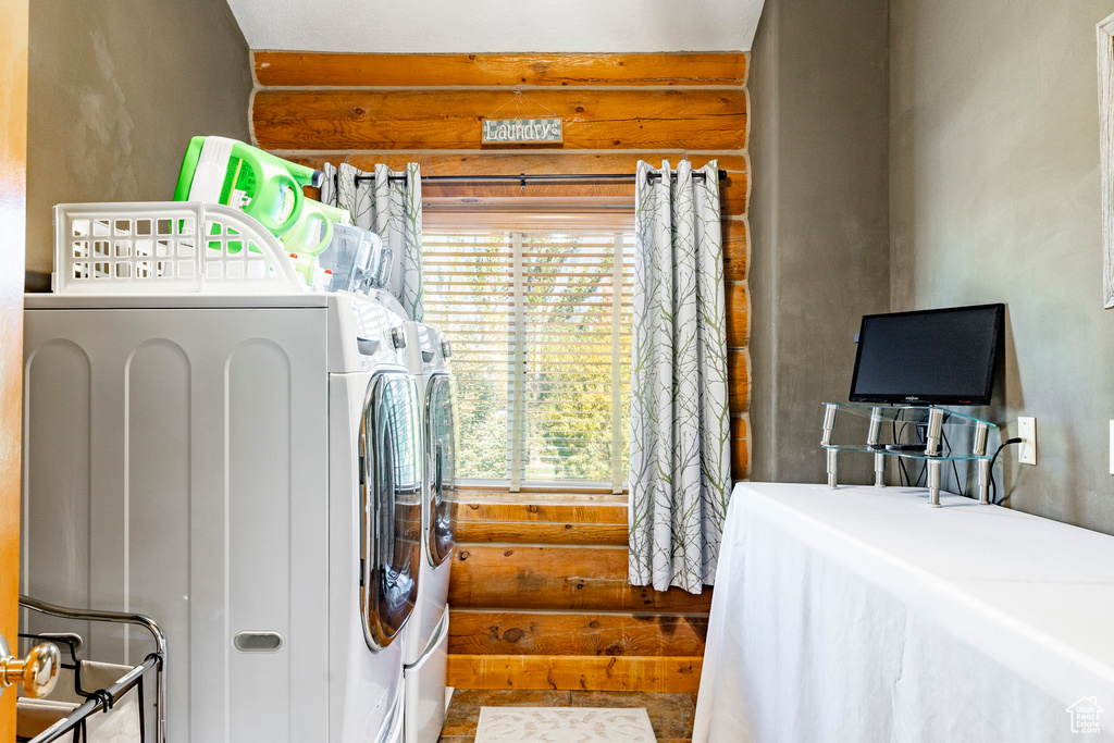 Laundry room with washer and dryer, plenty of natural light, and rustic walls