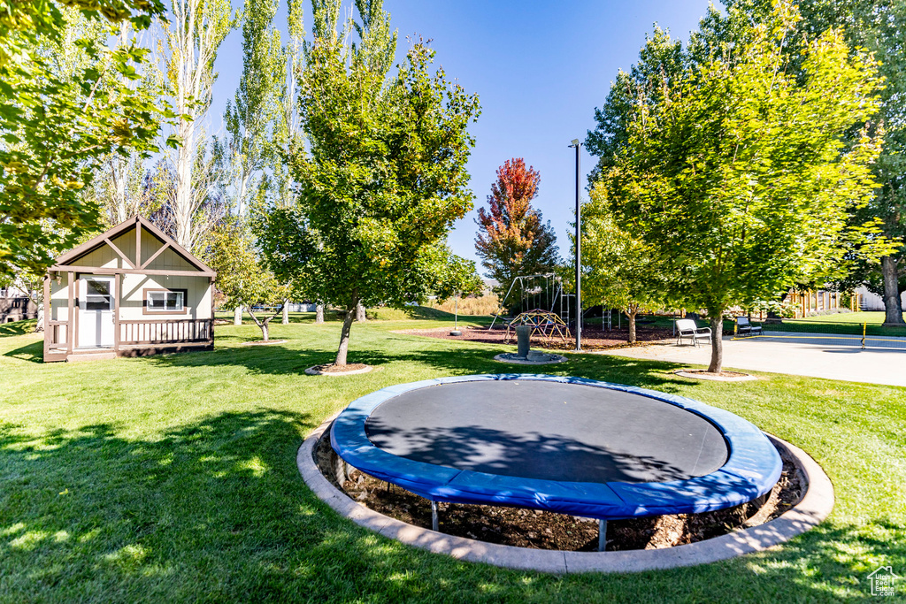 View of home\'s community with a trampoline and a yard