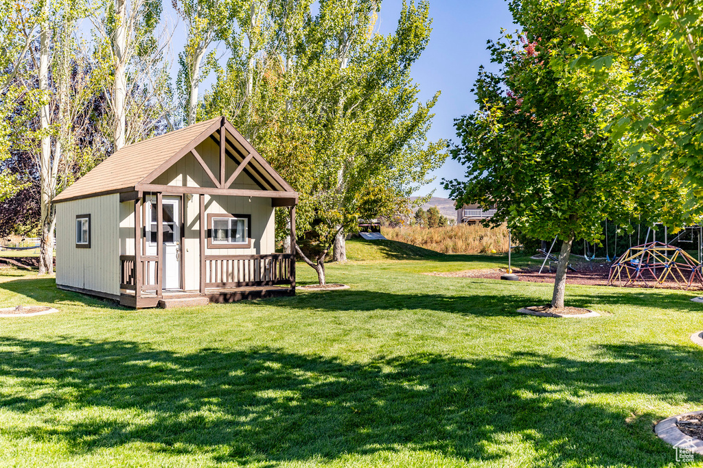 View of grassy yard featuring an outbuilding