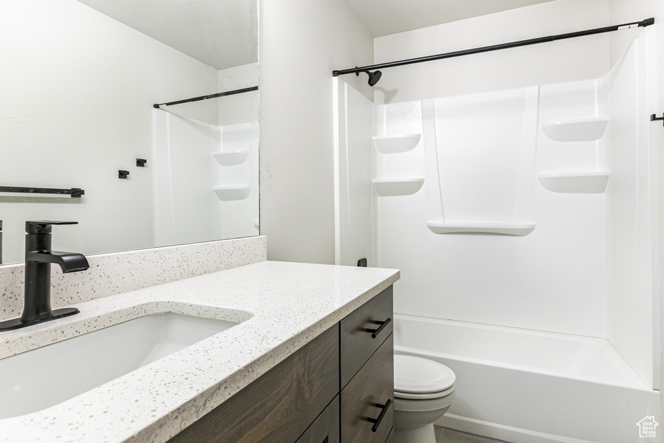 Full bathroom featuring bathing tub / shower combination, toilet, and vanity