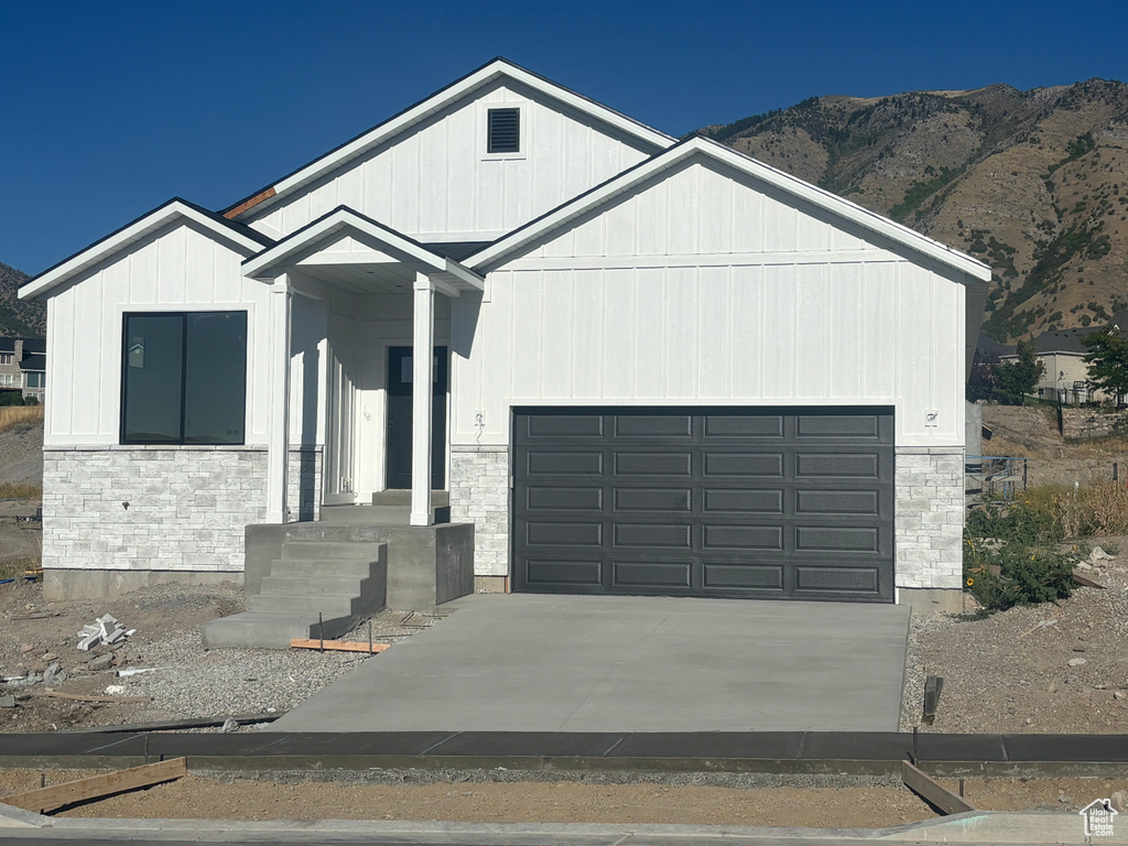 View of front of house with a mountain view and a garage