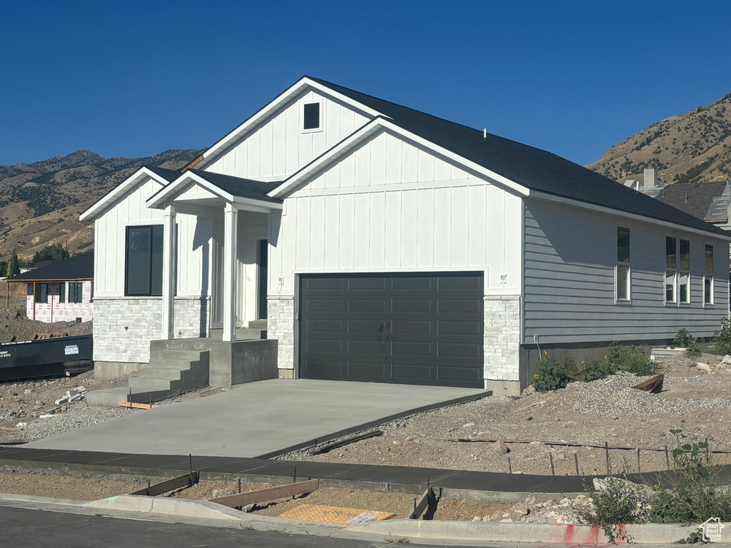 View of front facade with a garage and a mountain view