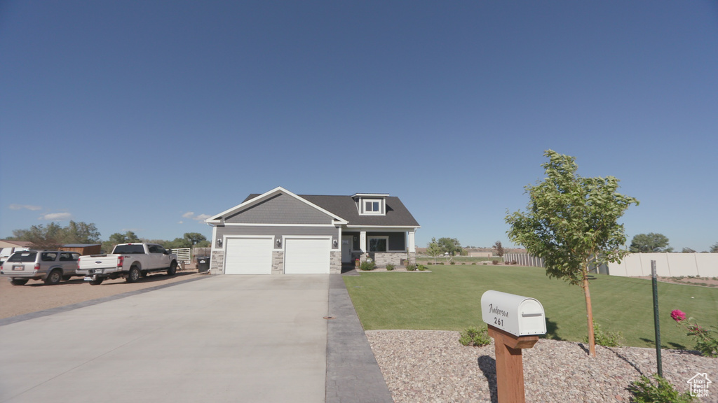 Craftsman house featuring a garage and a front lawn
