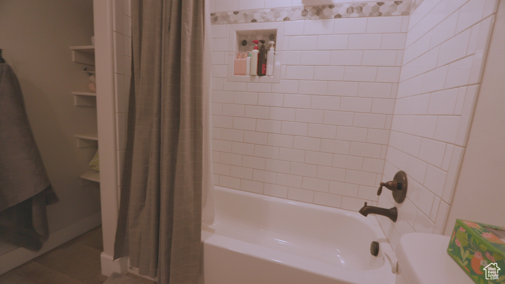 Bathroom with shower / bathtub combination with curtain and tile flooring