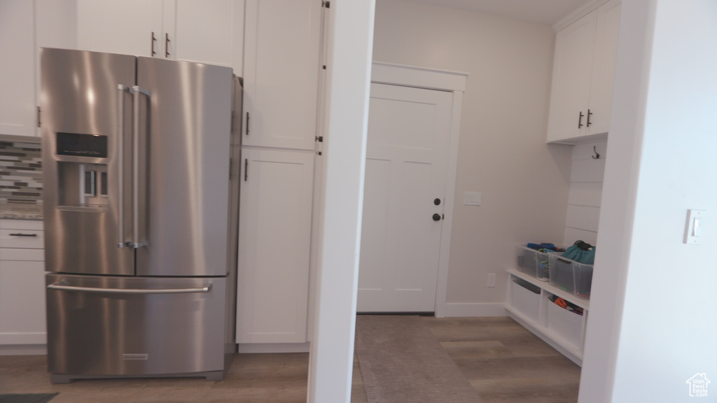 Kitchen featuring white cabinetry, wood-type flooring, and high end refrigerator