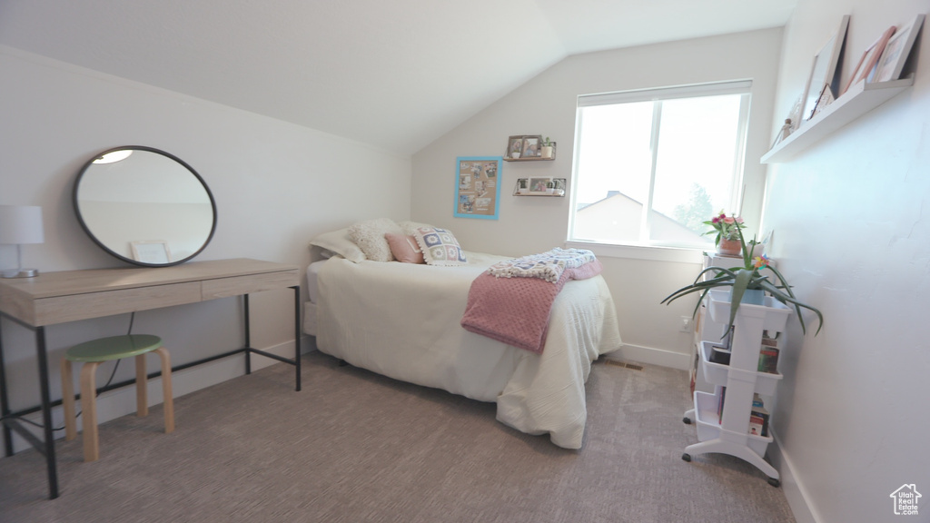 Carpeted bedroom featuring vaulted ceiling