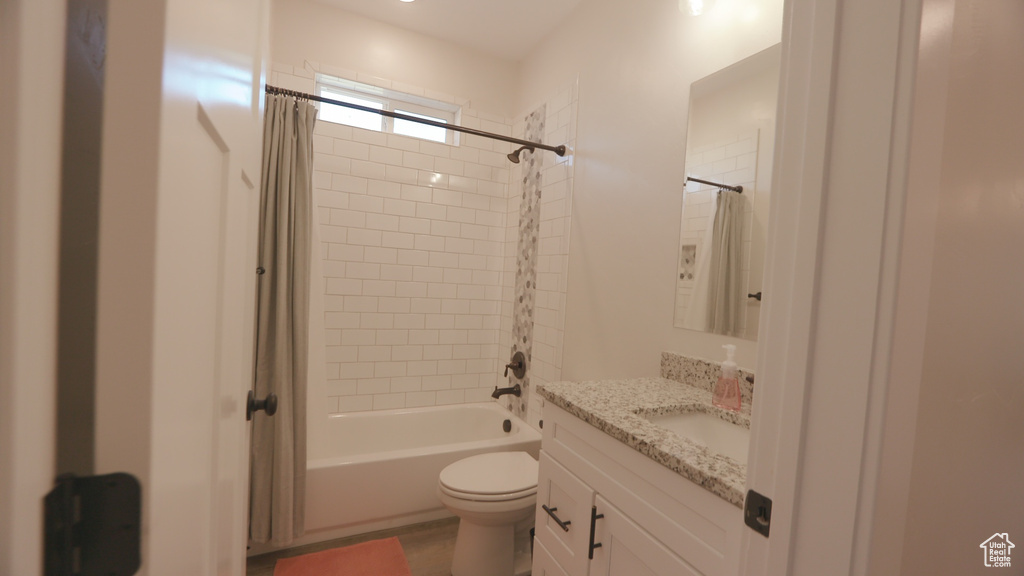 Full bathroom with shower / bath combo, oversized vanity, and toilet