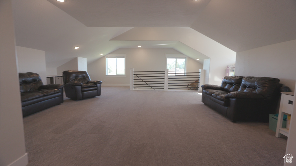 Living area with vaulted ceiling and carpet flooring