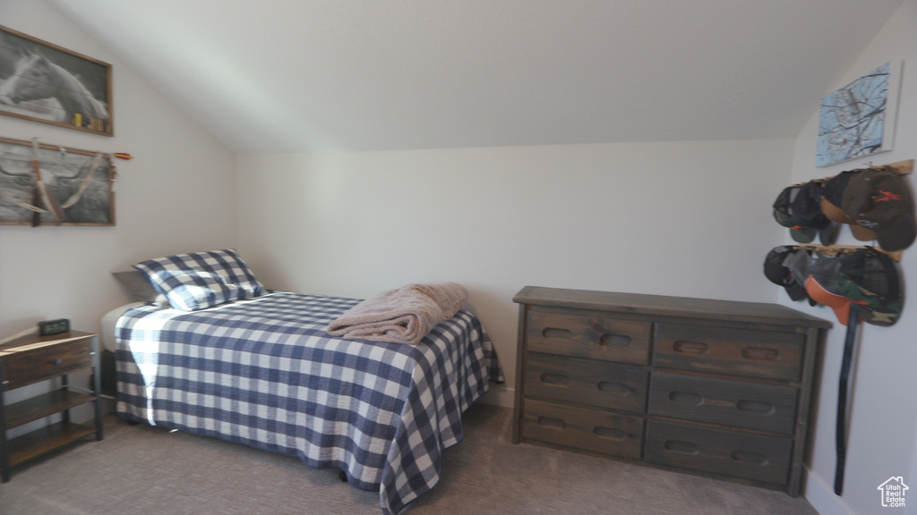 Bedroom with lofted ceiling and dark carpet