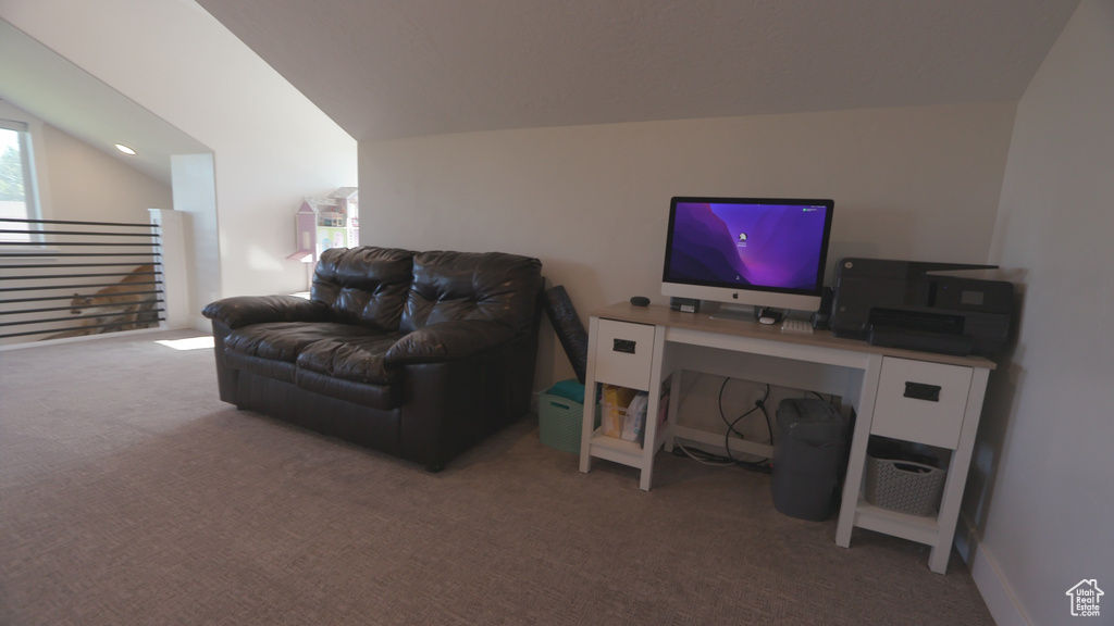Carpeted living room featuring vaulted ceiling