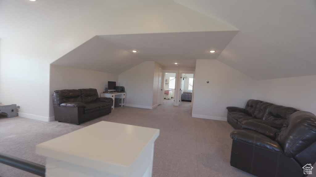 Carpeted living room with lofted ceiling