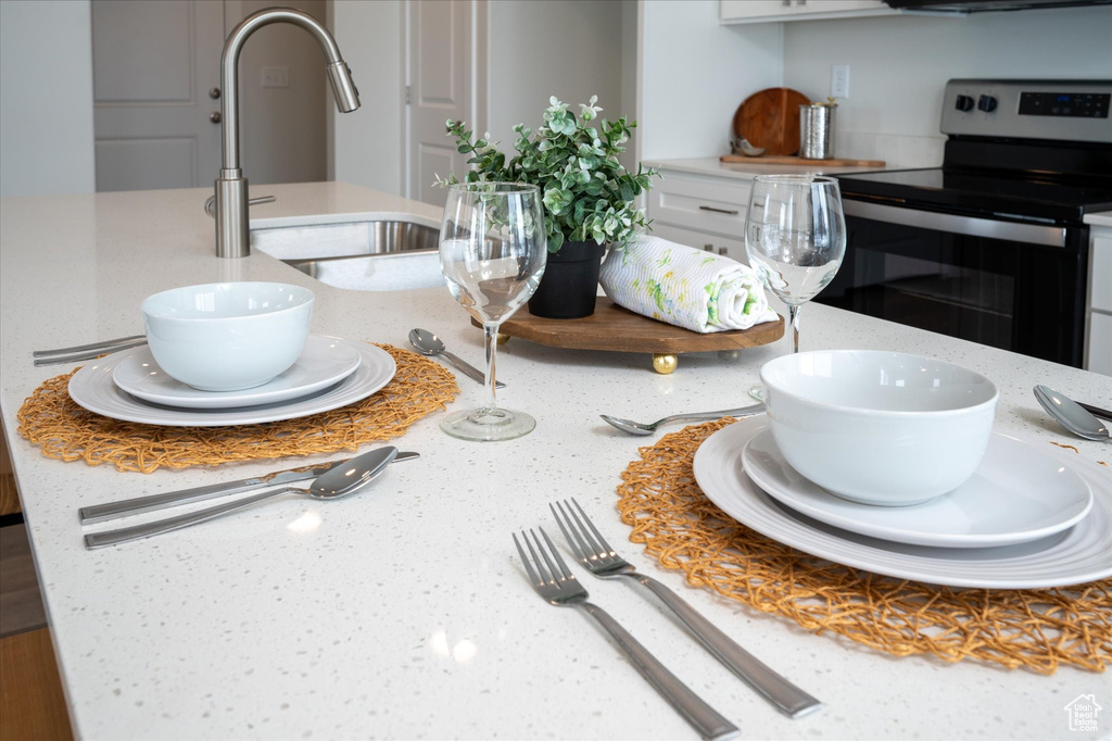 Room details featuring sink and stainless steel electric range oven