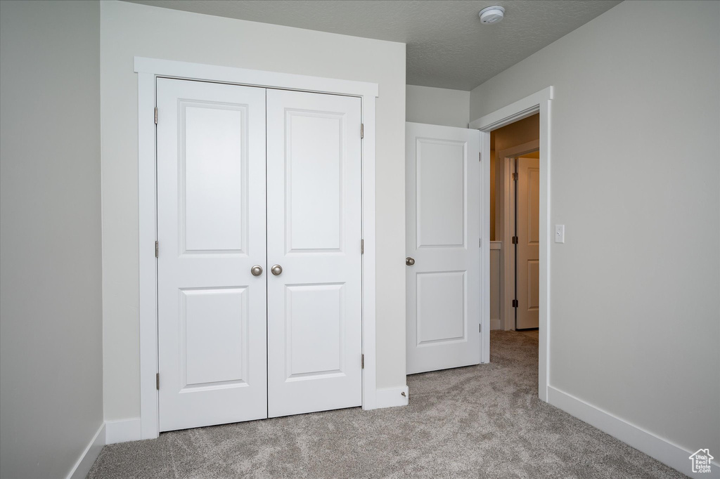 Unfurnished bedroom with a closet and light colored carpet