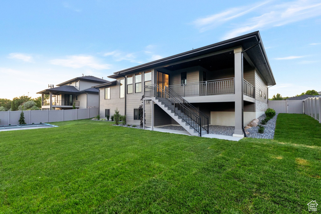 Rear view of house featuring a pool and a lawn