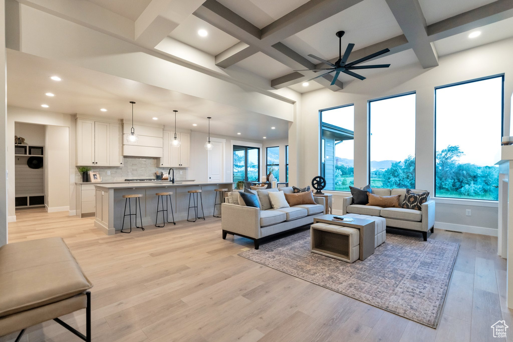 Living room with beamed ceiling, coffered ceiling, light wood-type flooring, and ceiling fan