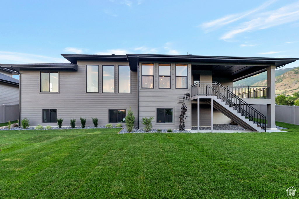 Rear view of property with a lawn