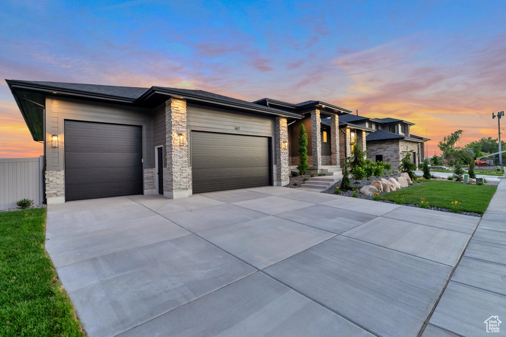 View of front facade with a garage and a yard