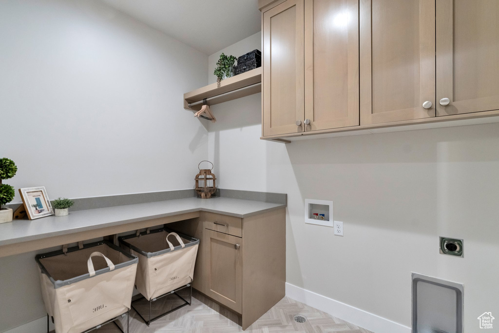 Laundry room featuring hookup for an electric dryer, hookup for a washing machine, light parquet flooring, and cabinets