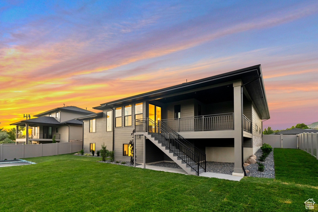 Back house at dusk with a lawn