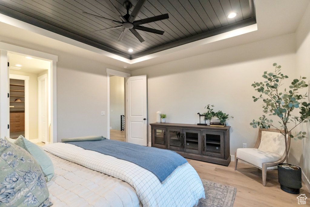 Bedroom featuring ceiling fan, a tray ceiling, and hardwood / wood-style floors