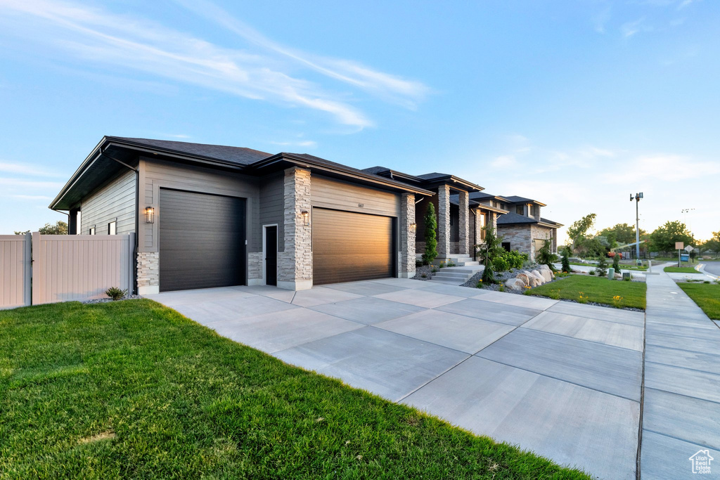 Prairie-style home with a garage and a front yard