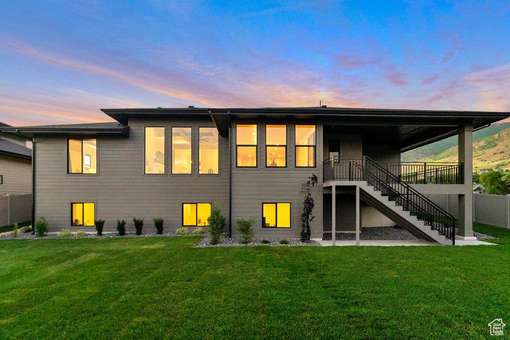 Back house at dusk with a lawn