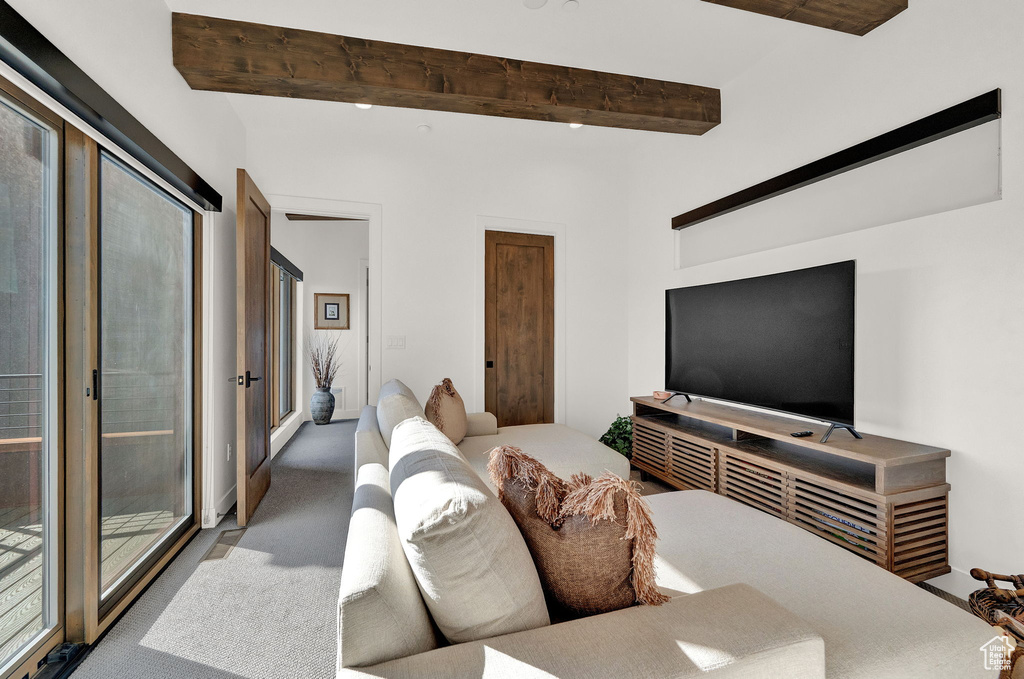 Living room featuring carpet and beamed ceiling